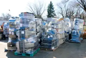 Pallets of discarded electronics stacked outdoors
