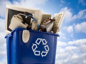 Blue recycling bin filled with discarded tech and circuit boards
