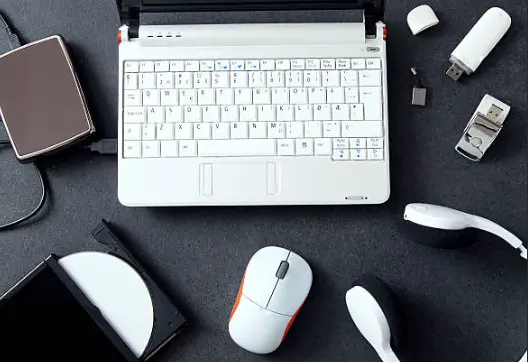 Laptop with white keyboard and computer accessories